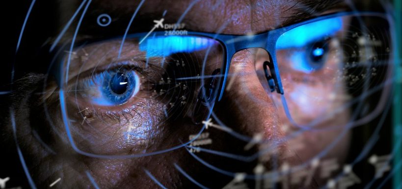 Fluglotse mit Brille vor Radar
